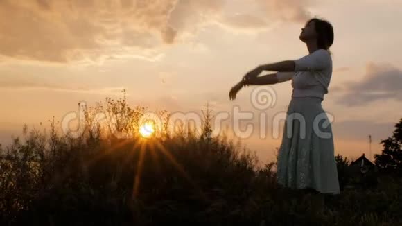 年轻美丽的女人在大自然中转向上帝女孩祈祷时双手交叉在下巴宗教观念视频的预览图