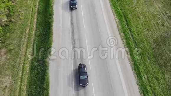 在阳光明媚的一天汽车沿着空旷的乡村道路行驶在空中视野视频的预览图