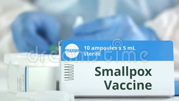 桌子上放着天花疫苗的盒子对着模糊的实验室助理小说制药标志视频的预览图