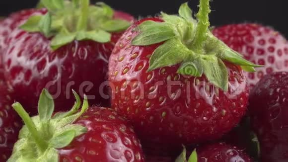美味的草莓在黑色背景上旋转视频的预览图