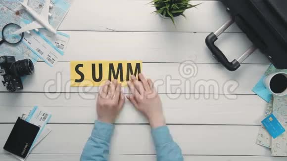 俯视图时间流逝的双手躺在白色的书桌上夏天装饰着旅行用品视频的预览图