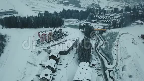 从山顶上看冬天的山森林和白雪覆盖的小城镇视频的预览图