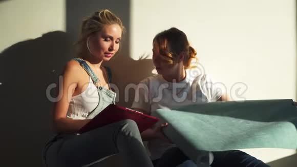 两个女孩在工地上讨论为他们的公寓选择壁纸视频的预览图