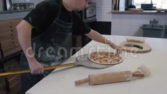 厨师在烤箱里准备意大利香肠披萨从后面看跟着在烤箱里做饭视频的预览图