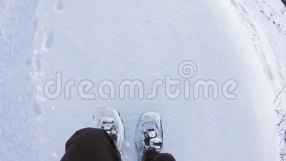 头顶的POV男子徒步旅行和步行与雪鞋户外白色雪道在山野野地在冬季细节视频的预览图