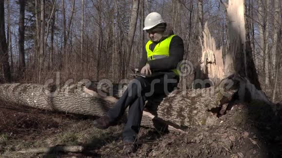公园里的伐木工人坐着看文件视频的预览图