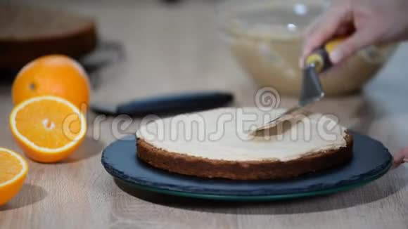 糖果师把奶油放在蛋糕的顶部面包师平滑蛋糕与奶油糖霜视频的预览图