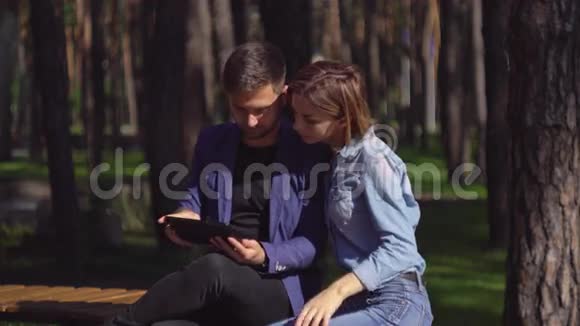 情侣使用现代设备和笑在户外视频的预览图