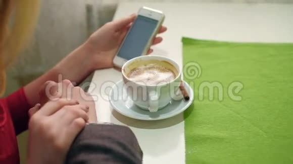 快乐的一对情侣在咖啡馆里用手机自拍视频的预览图