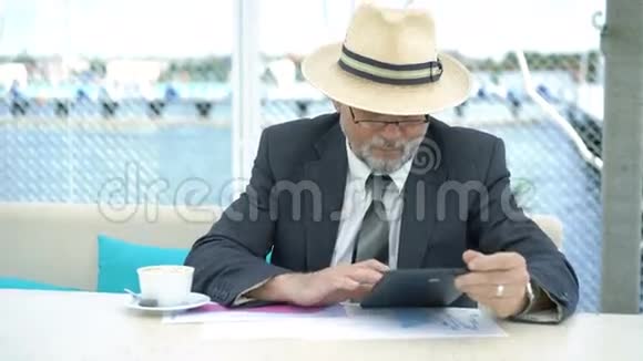 老人用平板电脑工作并在平板电脑上写下4K视频的预览图