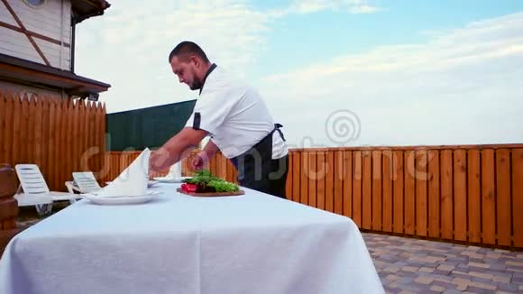 在家做饭专业厨师在露台上提供一张桌子一张桌子上铺着白色桌布和餐巾纸视频的预览图