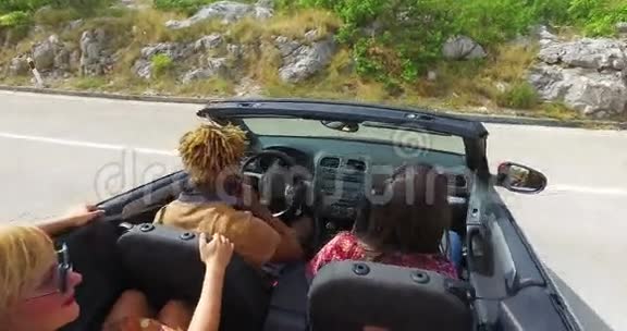 一群朋友乘坐红色敞篷车在高速公路上转弯视频的预览图