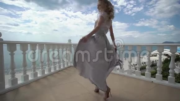 年轻的金发女郎穿着内衣在露台上摆着海景视频的预览图