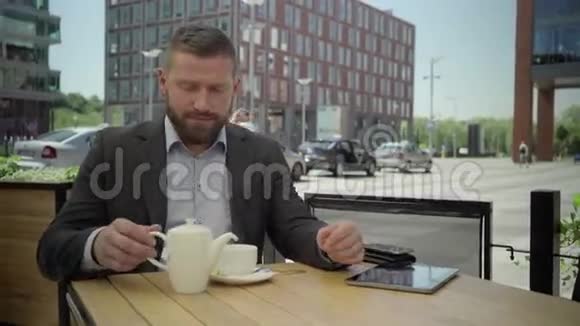 商人把茶倒进杯子里尝一尝Stadicam视频的预览图