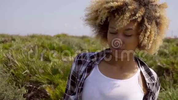 头发卷曲的年轻女子低头视频的预览图