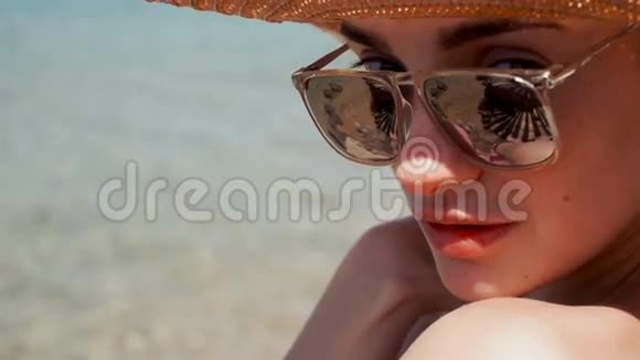 戴草帽和镜子太阳镜的年轻女子视频的预览图