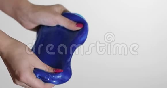 女人的手玩着奇怪的令人满意的蓝色黏液粘性物质抗压力视频的预览图