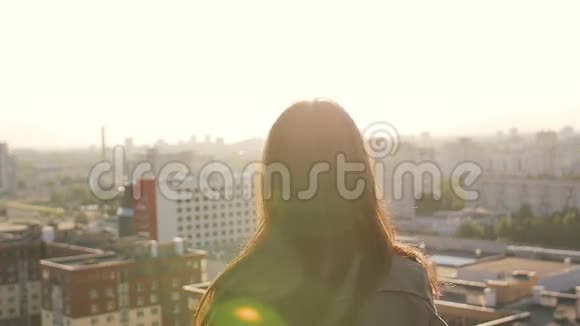 日落时年轻女子站在屋顶上跳跃慢节奏视频的预览图