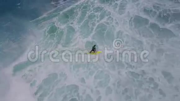 专业冲浪者在蓝色绿松石海水中的白色泡沫巨浪中滑行令人叹为观止的4k空中海景视频的预览图