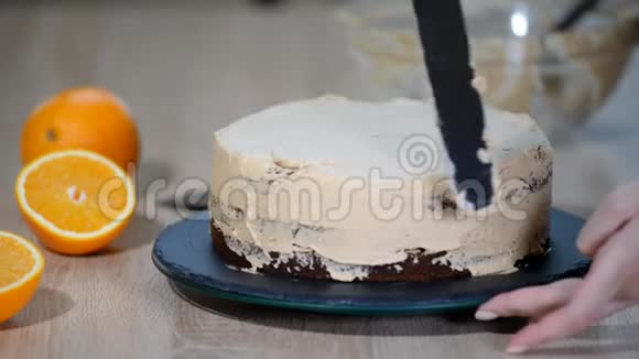 糖果师把奶油放在蛋糕的顶部面包师平滑蛋糕奶油糖霜视频的预览图