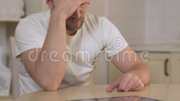 沮丧的男性坐在桌旁思考问题危机视频的预览图