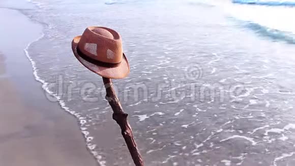 海滩上戴着棕色帽子的沙滩景色海浪拍打后海水涌到海滩上视频的预览图