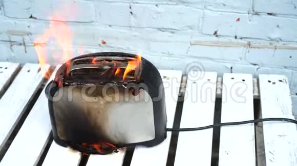 燃烧的烤面包机烤面包机两片烤面包片在白色背景下着火视频的预览图