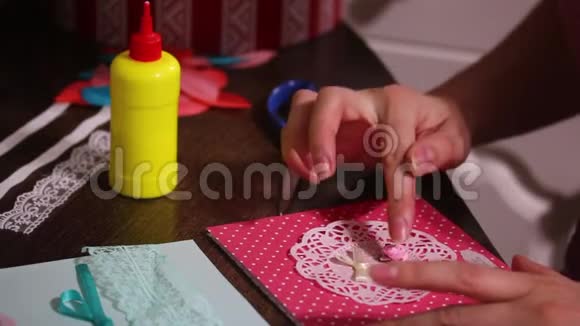 女人用纸花边和其他临时材料制作明信片视频的预览图