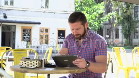 早餐时男士通过平板电脑在线支付卡滑杆右射视频的预览图