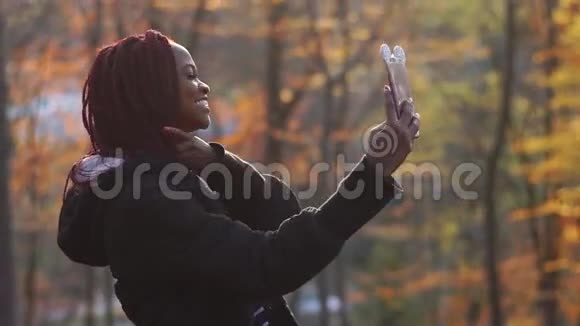 在秋天公园自拍的美国女孩微笑的侧面肖像视频的预览图