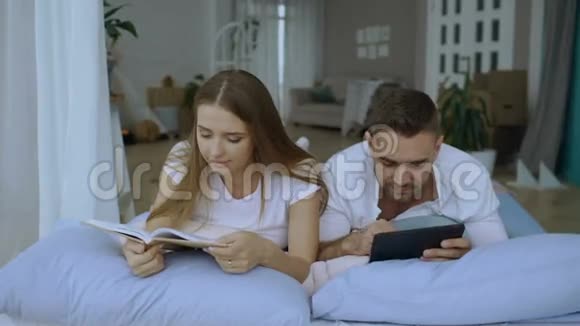 帅哥用平板电脑给女朋友看书躺在床上看平板电脑上的照片视频的预览图