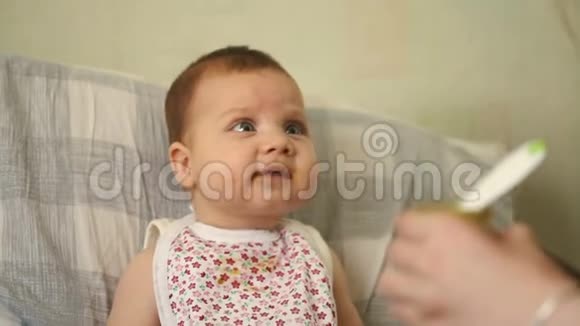 幼妈妈用勺子喂婴儿食品视频的预览图