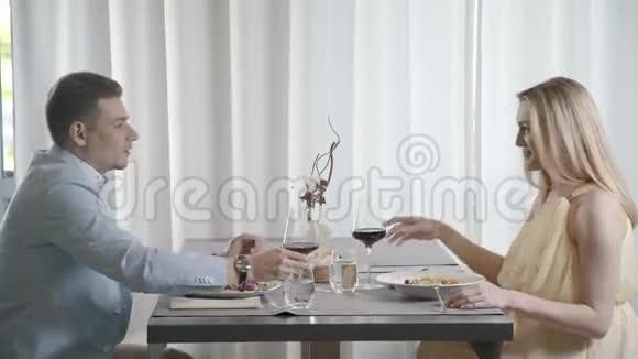 漂亮的一对夫妇坐在餐厅对面吃晚饭视频的预览图