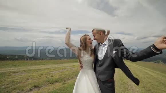新郎新娘在山上玩得开心新婚夫妇幸福家庭视频的预览图