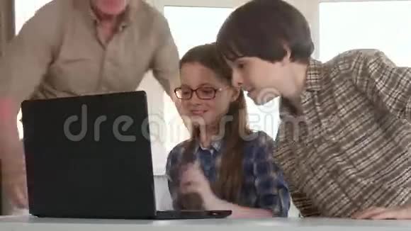 老人和他的孙子们在笔记本电脑上娱乐视频的预览图