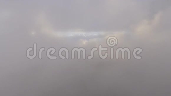 4k无人机摄像机在乡间绿野上空的蓝天高空飞过蓬松的灰色雨云视频的预览图