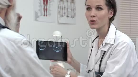 医生微笑着在药片上谈论x光好消息视频的预览图