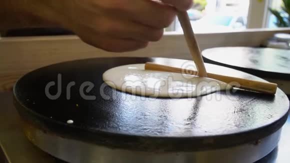 厨师把面糊放在煎锅里在煎锅上慢慢做煎饼视频的预览图