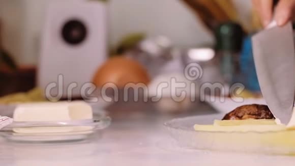 一个拿着刀的女人把黄油放在盘子里上面放着食物视频的预览图