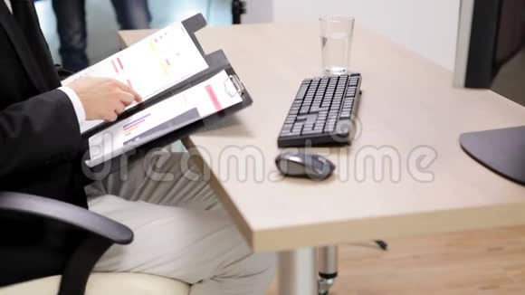 办公桌上的办公室工作人员键盘放在飞机文件夹旁边视频的预览图