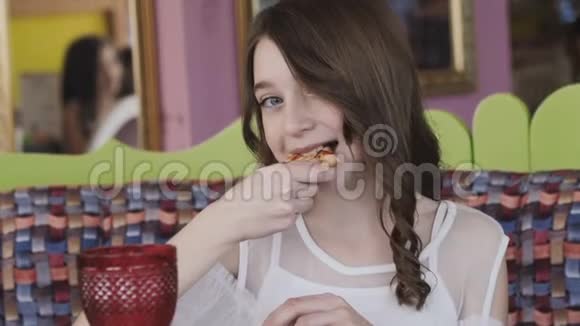在咖啡馆里吃披萨的漂亮女孩慢慢地视频的预览图