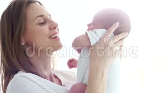一位快乐的母亲抱着一个两周大的婴儿在怀里快乐的母亲母亲节视频的预览图