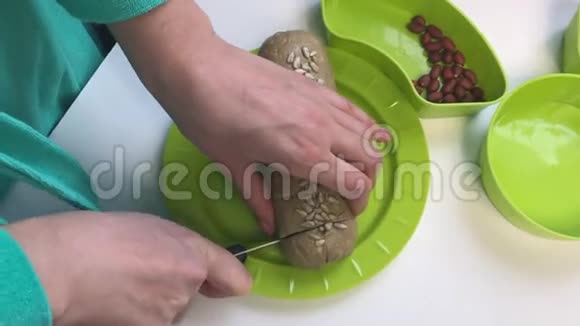 一个女人用碎花生葵花籽和蜂蜜把香肠切成一部分哈尔娃在家做饭视频的预览图