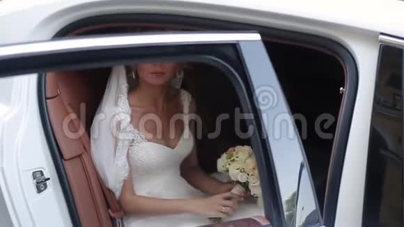 年轻的金发新娘坐在车里视频的预览图