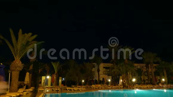 提供照明和棕榈树的夜间游泳池在豪华的时间流逝视频的预览图