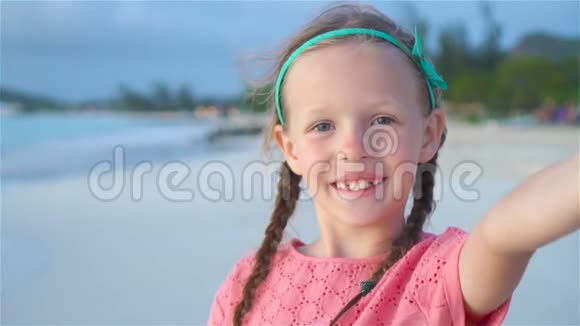 可爱的小女孩在热带白色海滩自拍慢动作视频的预览图