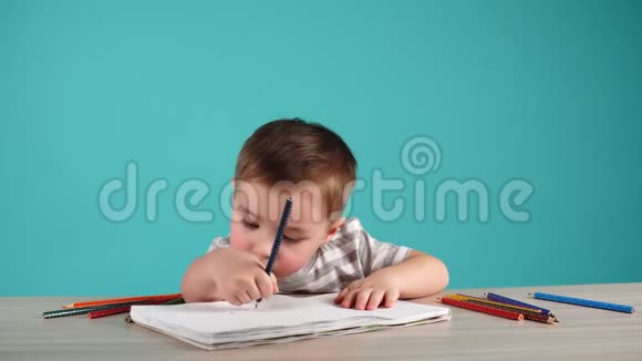 小男孩在桌子上用彩色铅笔画画视频的预览图