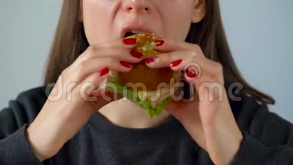 女人吃多汁的汉堡包视频的预览图