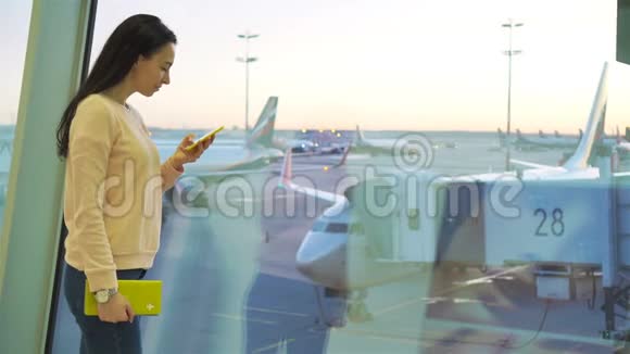航空公司乘客在机场休息室等待航班飞机白种人女人在大窗户附近用手机说话视频的预览图