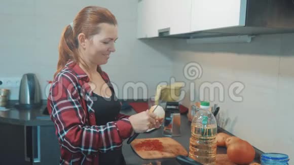 厨房里的女人正在用刀子清洗洋葱女孩做饭在厨房的概念女人在清洗蝴蝶结视频的预览图